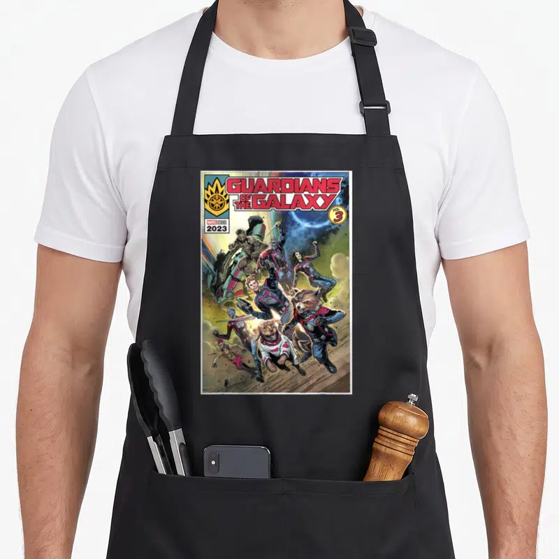 Guardian cosmo apron - Guardians of the Galaxy Vol 3 characters leaping forward in comic book style — shown on a black cotton canvas apron against a white background