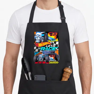 Bone race girl apron - Hot Wheels car with skull engine and let's race text over checkered flag — shown on a black cotton canvas apron against a white background