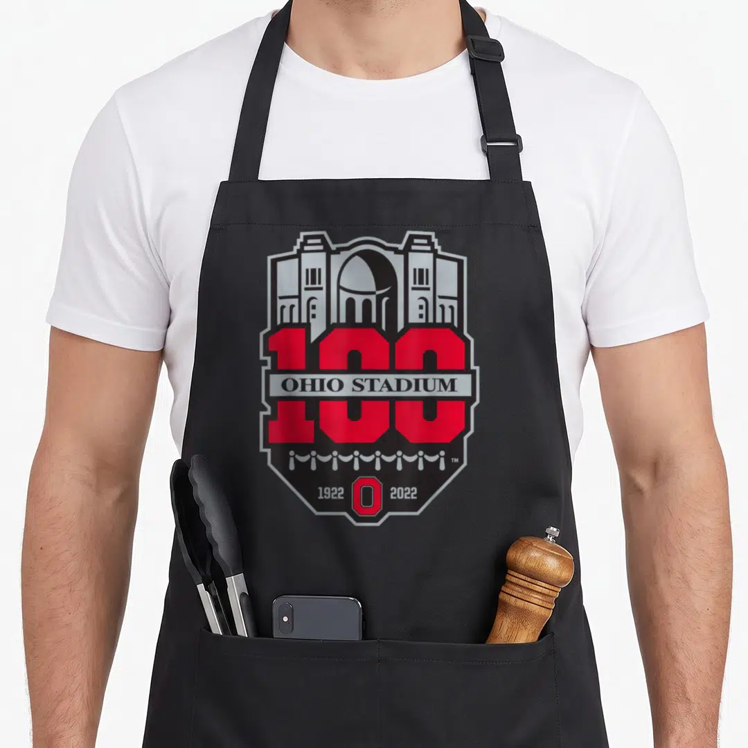 Cute football apron - Red and grey Ohio Stadium 100 year anniversary shield logo with dates 1922 and 2022 — shown on a black cotton canvas apron against a white background