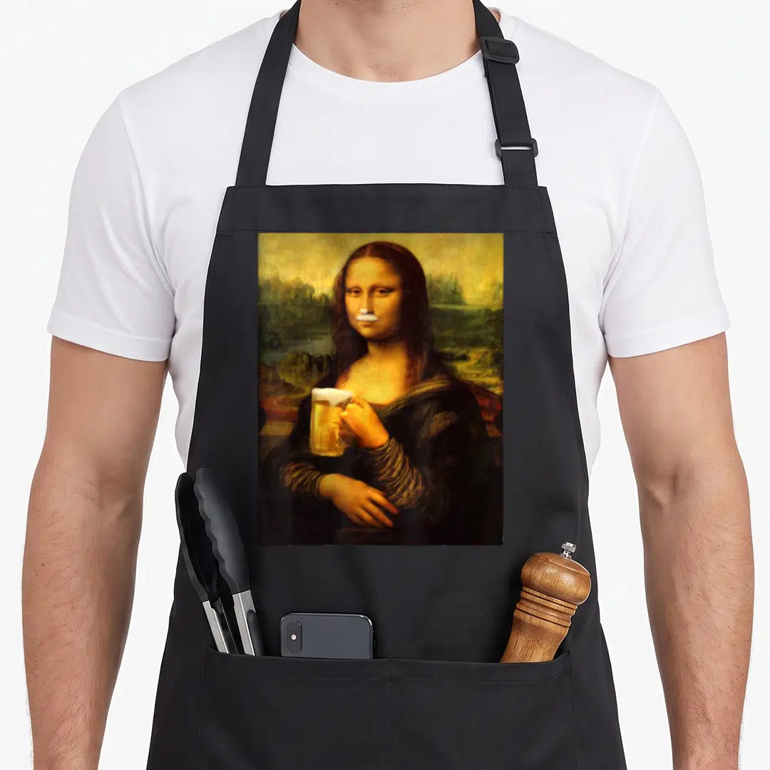 Mona beer apron - Mona Lisa holding beer mug with white foam mustache overlay in brown and gold tones — shown on a black cotton canvas apron against a white background