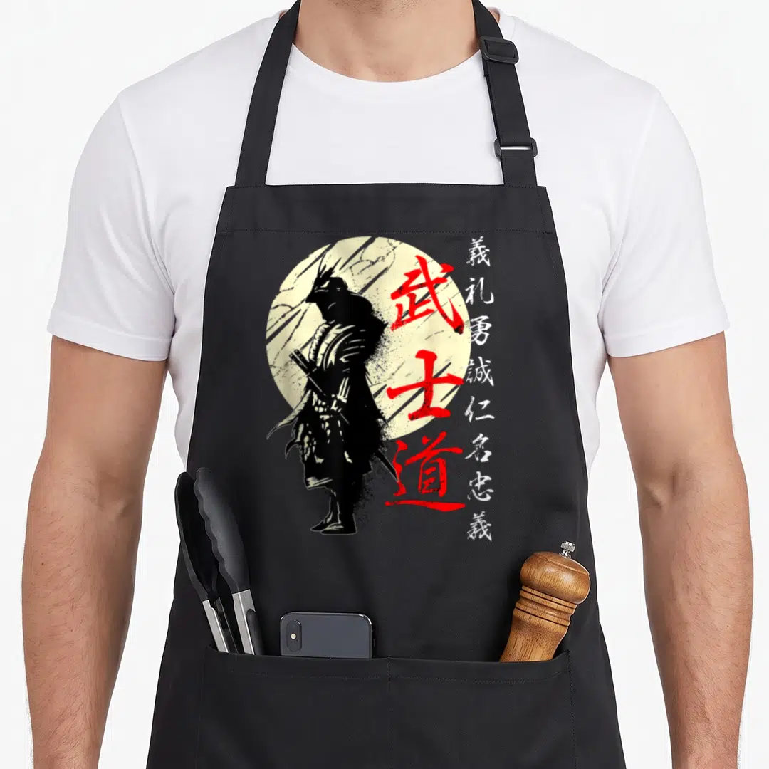 Samurai japan apron - Black samurai silhouette on pale sun with vertical red and white kanji calligraphy in distressed — shown on a black cotton canvas apron against a white background