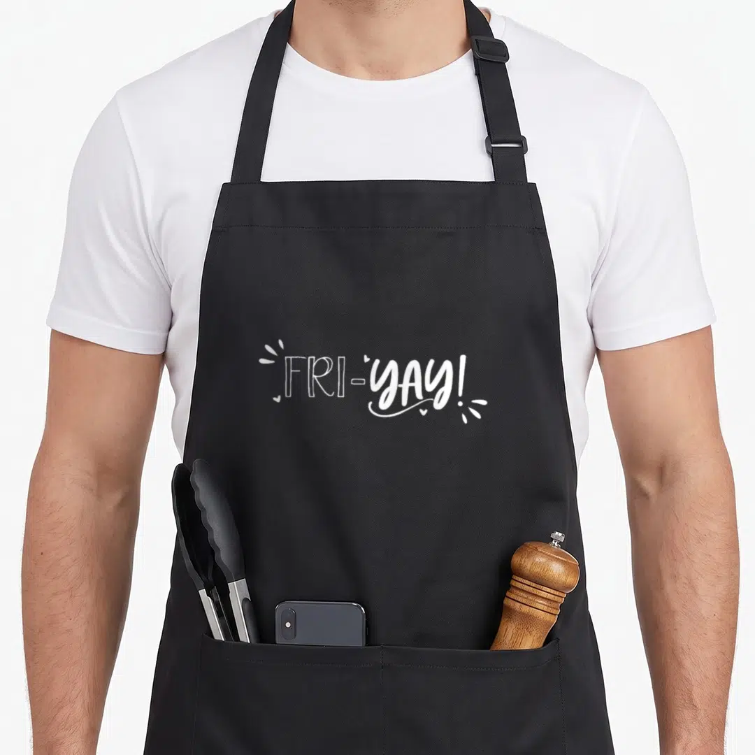 Weekend teacher apron - FRI-YAY! text in white with decorative sparkles and hearts — shown on a black cotton canvas apron against a white background