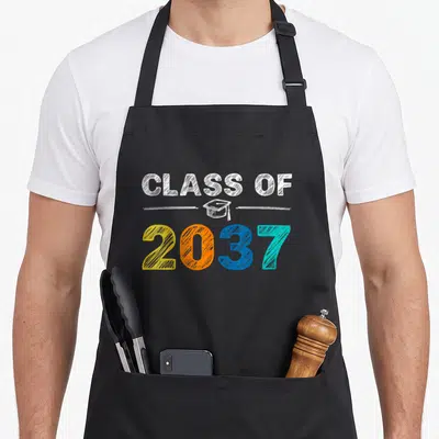 Grow school class first apron - CLASS OF 2037 text with cap in white yellow orange blue teal — shown on a black cotton canvas apron against a white background