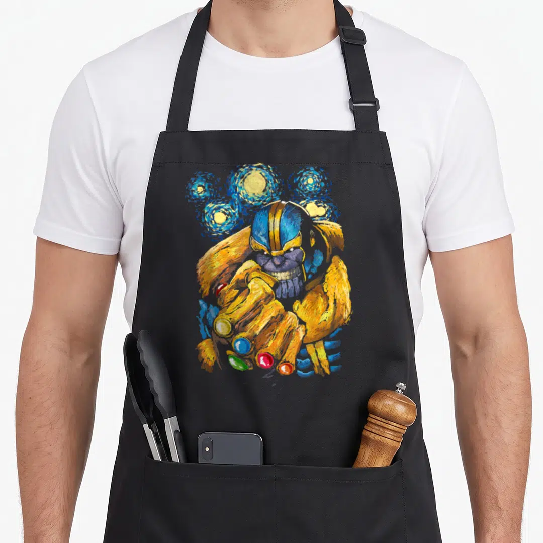 Starry wellness apron - Watercolor painting of Thanos holding a gold gauntlet with blue and yellow swirls — shown on a black cotton canvas apron against a white background