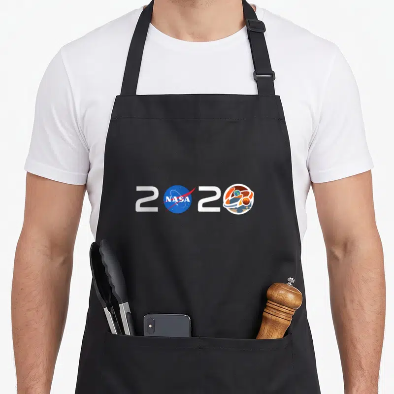 Jpl nasa apron - 2020 typography with NASA logo and Mars mission emblem in white blue orange — shown on a black cotton canvas apron against a white background