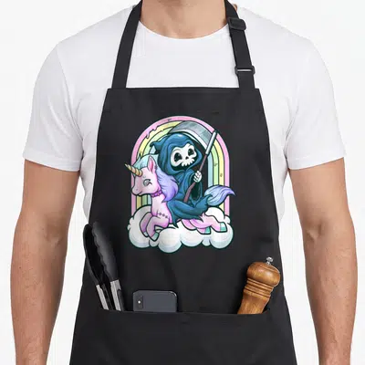 Unicorn goth apron - Cartoon Grim Reaper riding pink unicorn on cloud with rainbow — shown on a black cotton canvas apron against a white background