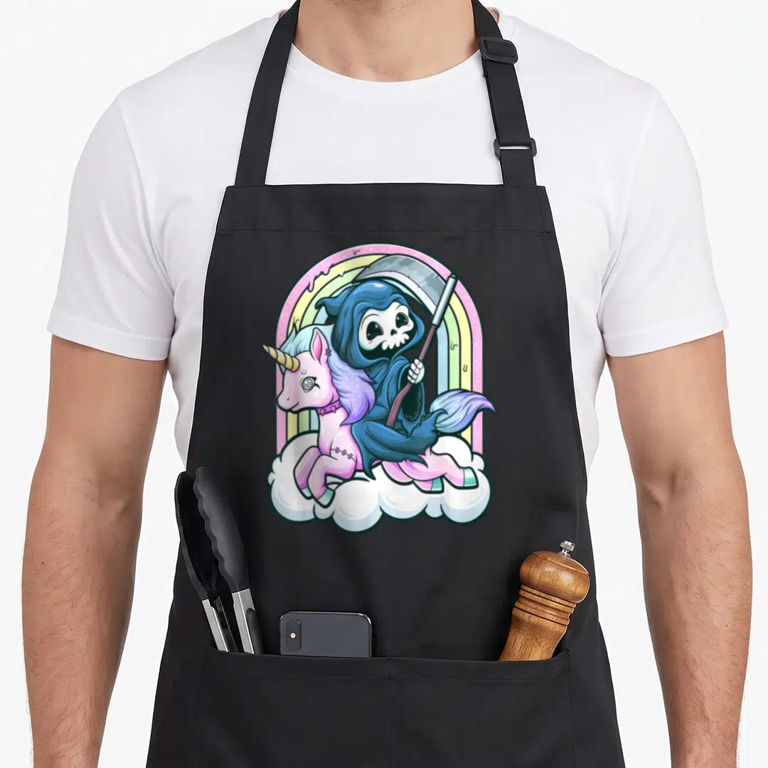 Unicorn goth apron - Cartoon Grim Reaper riding pink unicorn on cloud with rainbow — shown on a black cotton canvas apron against a white background