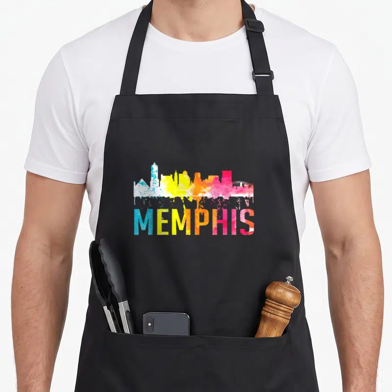 Watercolor memphis apron - Blue yellow orange pink watercolor skyline above MEMPHIS text — shown on a black cotton canvas apron against a white background