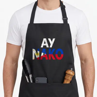 Pinoy nako filipino apron - Stacked text AY NAKO with Philippine flag colors white blue red yellow distressed font — shown on a black cotton canvas apron against a white background