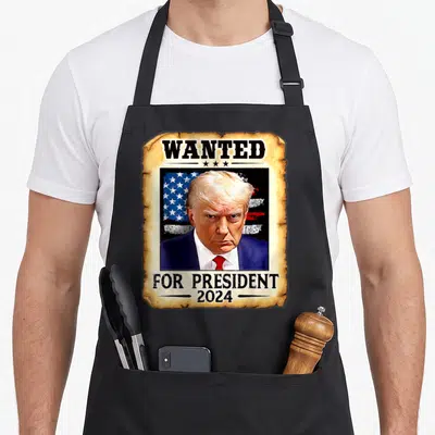 Donald presidents apron - Wanted poster graphic of Donald Trump with American flag and 2024 text — shown on a black cotton canvas apron against a white background