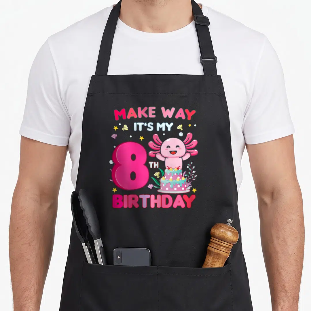 Way 8th birthday apron - Pink axolotl with number 8, cake, and birthday text surrounded by stars and bubbles — shown on a black cotton canvas apron against a white background