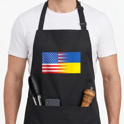 Retro ukrainian american flag apron - Merged US and Ukraine flags blending via halftone dot pattern in blue red white — shown on a black cotton canvas apron against a white background