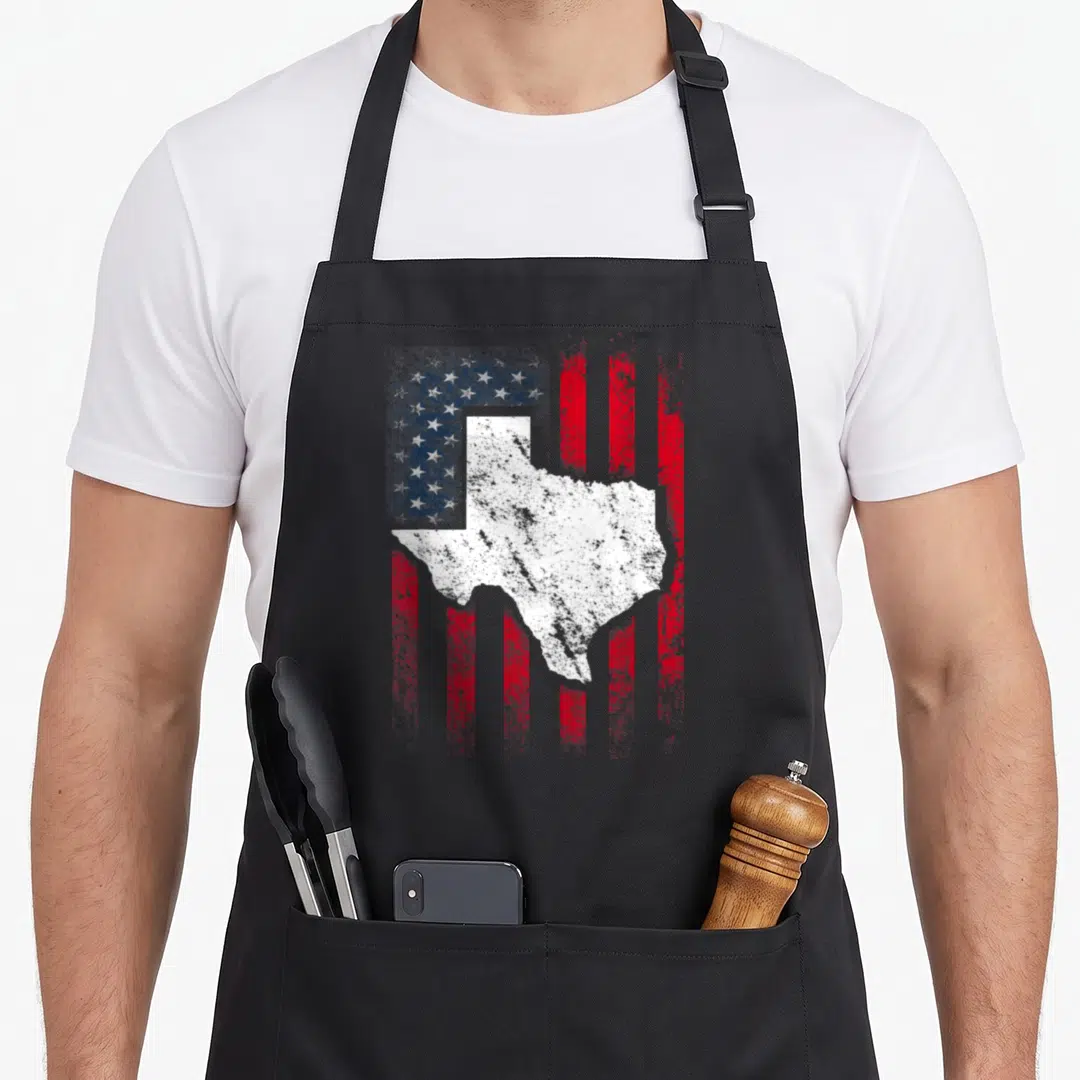 Flag texas aprons - White Texas map silhouette on distressed red white and blue flag pattern — shown on a black cotton canvas apron against a white background