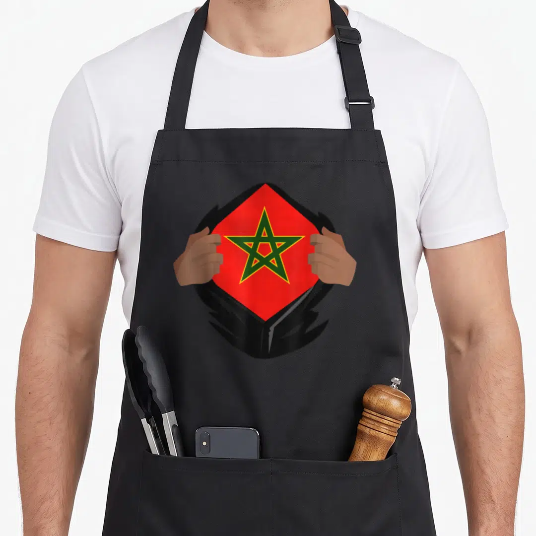 Proud moroccan girl apron - Hands tearing black shirt to reveal red flag with green star — shown on a black cotton canvas apron against a white background