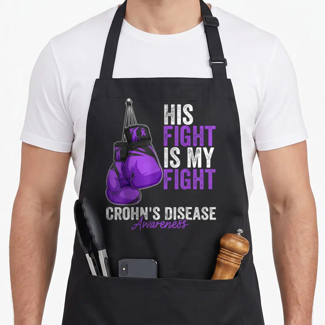 Glove ribbon apron - Purple boxing gloves with His Fight Is My Fight text and Crohn's Disease Awareness ribbon — shown on a black cotton canvas apron against a white background