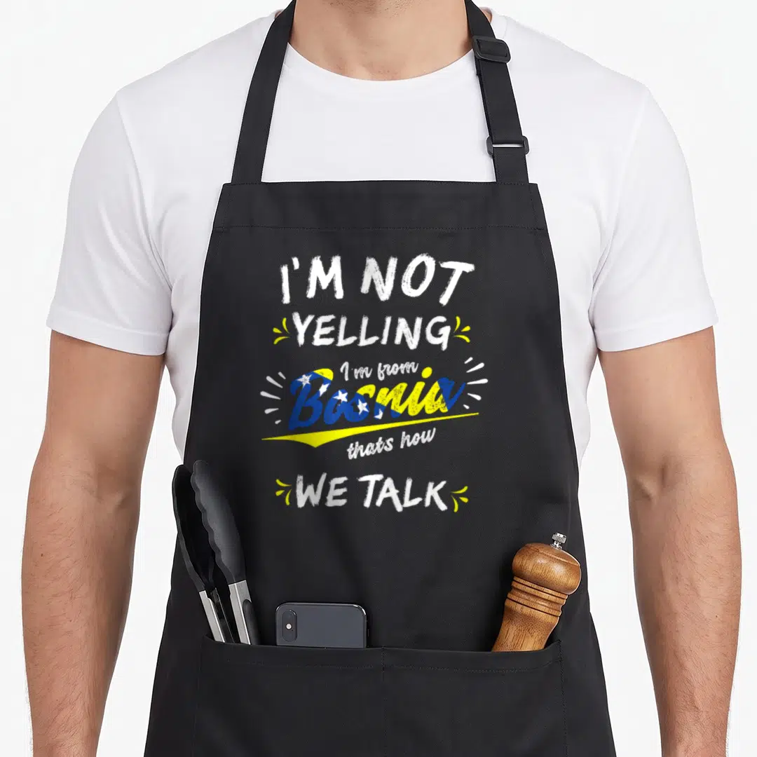 Bosnia bosnian girl apron - Stacked text reading I'M NOT YELLING I'm from Bosnia thats how WE TALK in white blue — shown on a black cotton canvas apron against a white background