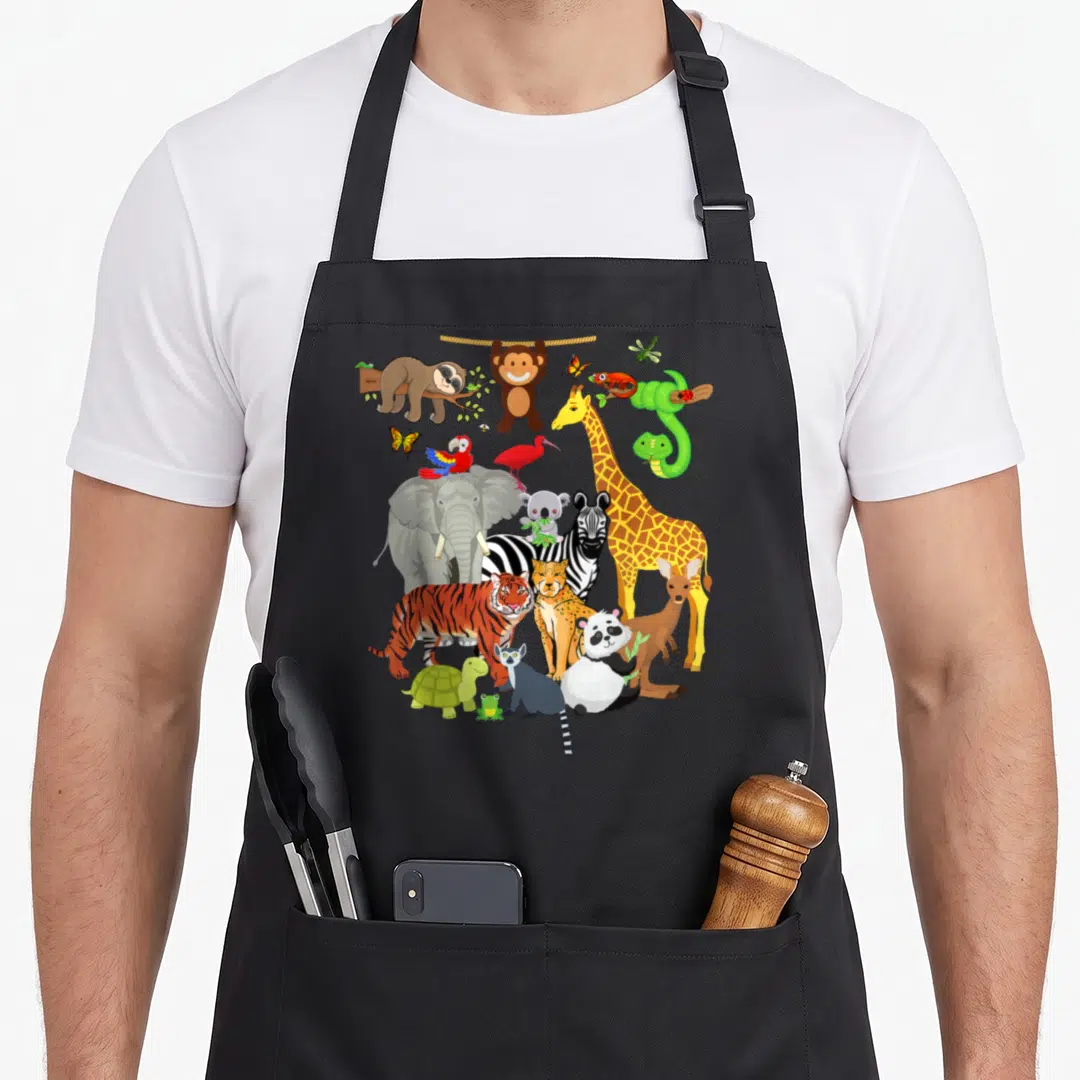 Zoo birthday apron - Cartoon giraffe zebra elephant tiger panda sloth monkey butterfly snake insect cluster in green — shown on a black cotton canvas apron against a white background
