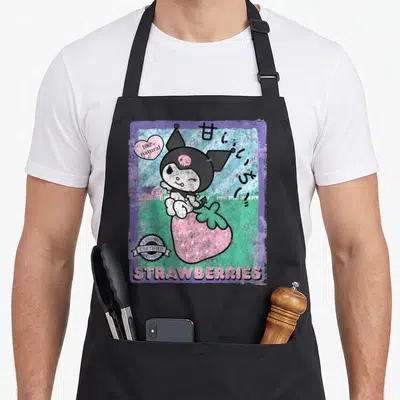 Strawberry farm apron - Kuromi sitting on pink strawberry with 100% natural text and Japanese characters — shown on a black cotton canvas apron against a white background