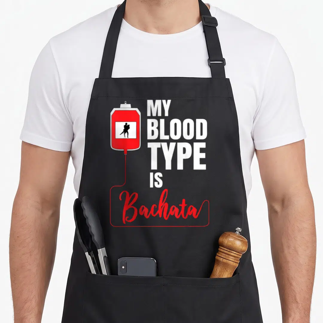 Dance bachata apron - Red blood bag with black dancer silhouette and My Blood Type Is Bachata text — shown on a black cotton canvas apron against a white background