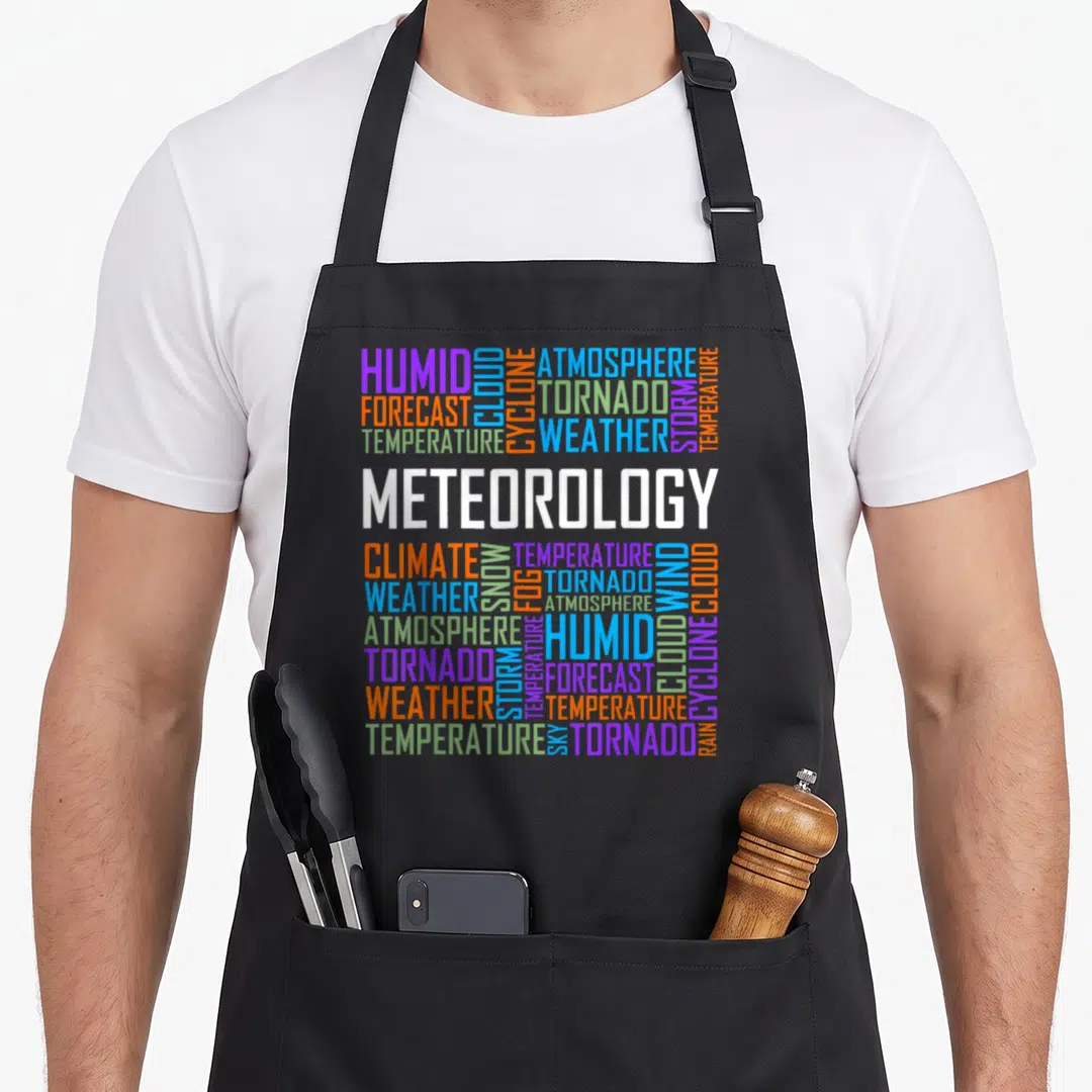Weather meteor apron - Word cloud of meteorology terms like Tornado and Storm in purple orange blue green and white — shown on a black cotton canvas apron against a white background