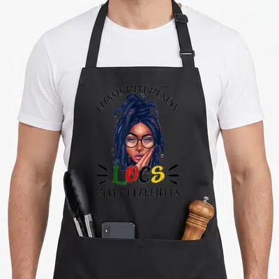 Loc glass husband apron - Woman with glasses and locs surrounded by text GLASSES MAKE ME SEXY LOCS MAKE ME DANGEROUS — shown on a black cotton canvas apron against a white background