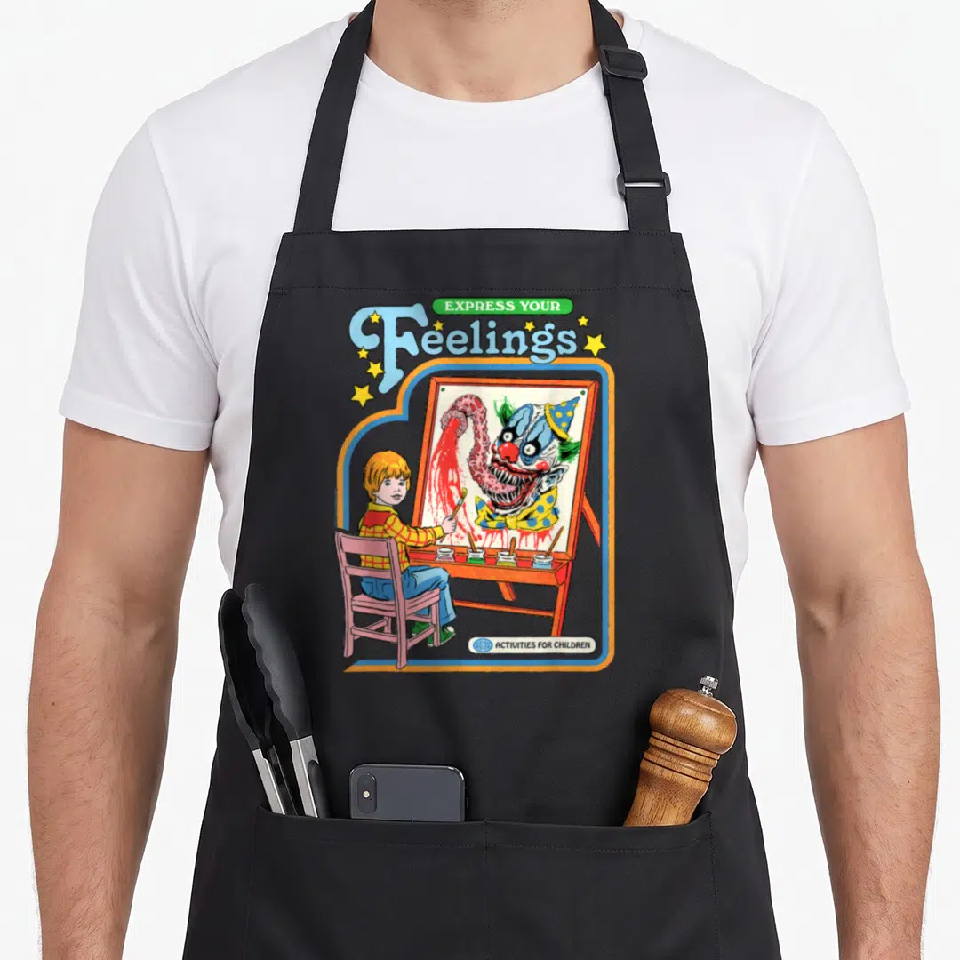 Steven clown aprons - Child painting monster clown with Express Your Feelings text in retro colors — shown on a black cotton canvas apron against a white background