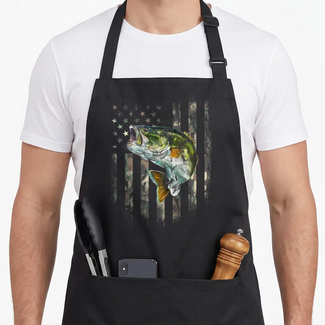 Camo american flag apron - Realistic bass fish over olive green grey tan camouflage US flag pattern — shown on a black cotton canvas apron against a white background