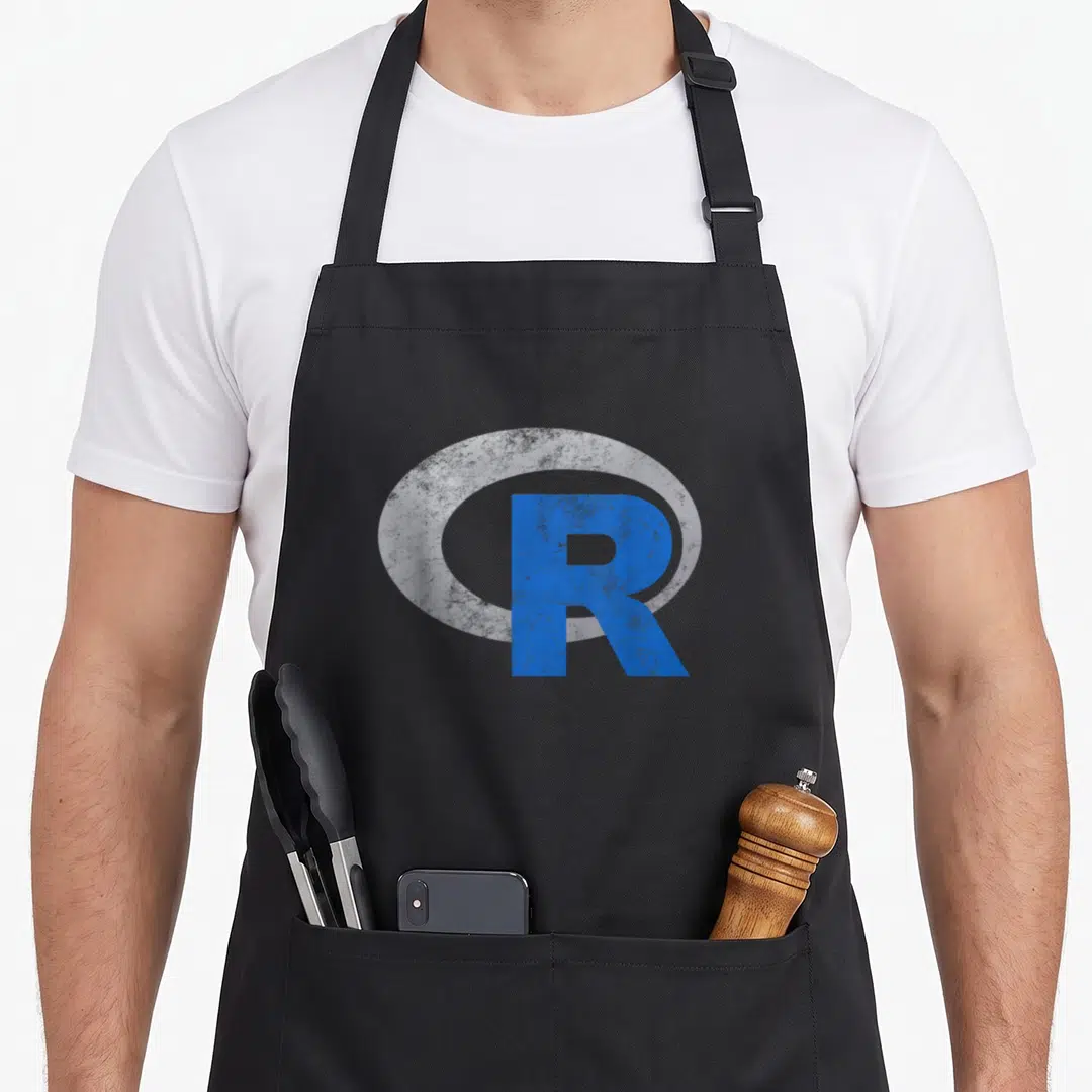 Programming data science apron - Blue distressed letter R superimposed on a white oval shape — shown on a black cotton canvas apron against a white background
