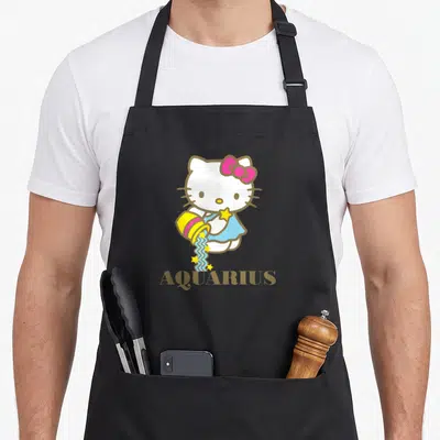 Vintage aquarius zodiac aprons - Hello Kitty pouring blue water with yellow stars above gold AQUARIUS text — shown on a black cotton canvas apron against a white background