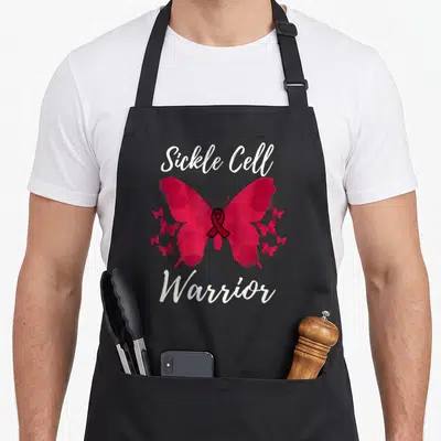 Funny warrior sickle cell awareness apron - Red watercolor butterfly with white Sickle Cell Warrior text and internal — shown on a black cotton canvas apron against a white background