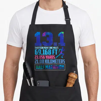 Mile running marathon apron - 13.1 text with distance stats and runner silhouette in blue pink green typography — shown on a black cotton canvas apron against a white background
