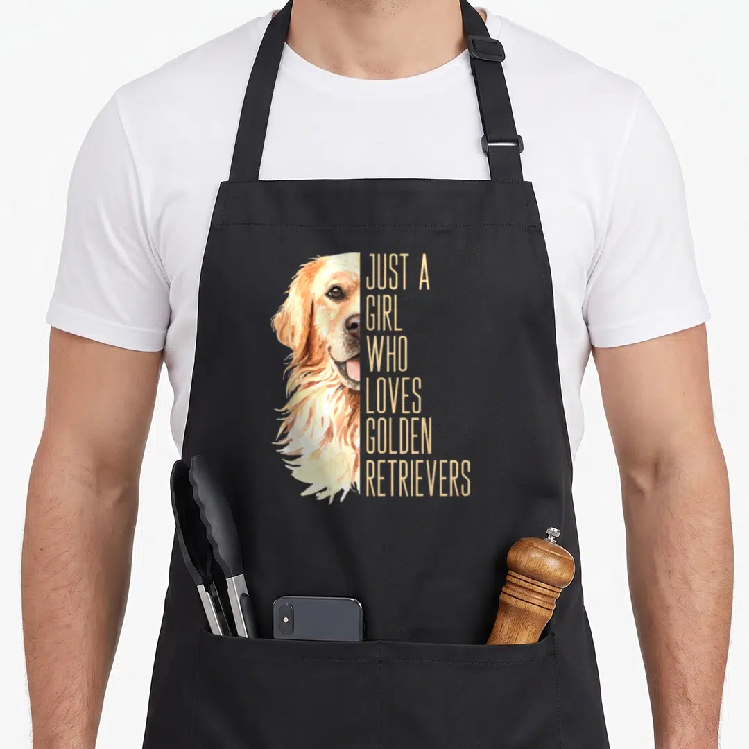 Enthusiast golden retriever apron - Watercolor golden retriever head next to stacked text reading just a girl who loves — shown on a black cotton canvas apron against a white background