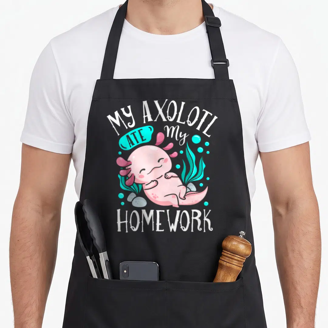 Axolotl student aprons - Pink cartoon axolotl with teal bubbles and white text MY AXOLOTL ATE my HOMEWORK — shown on a black cotton canvas apron against a white background