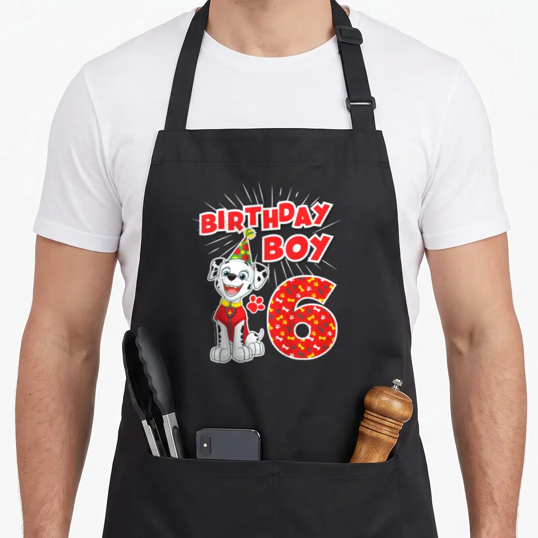 Merchandise marshalls apron - Dalmatian puppy wearing party hat next to red paw print and patterned number 6 — shown on a black cotton canvas apron against a white background