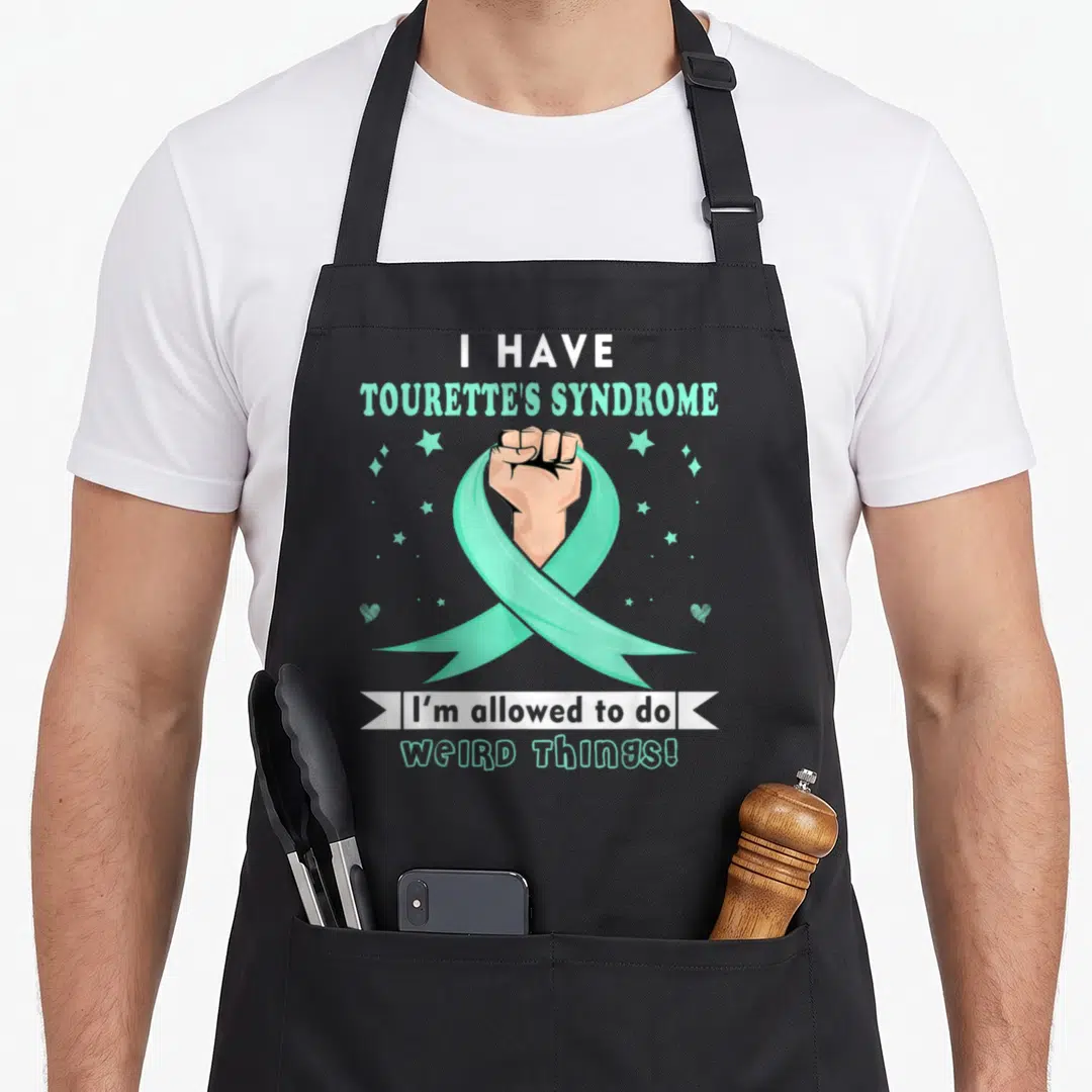 Retro syndrome tourette awareness apron - Fist holding mint green ribbon with text I have Tourette's Syndrome I'm — shown on a black cotton canvas apron against a white background