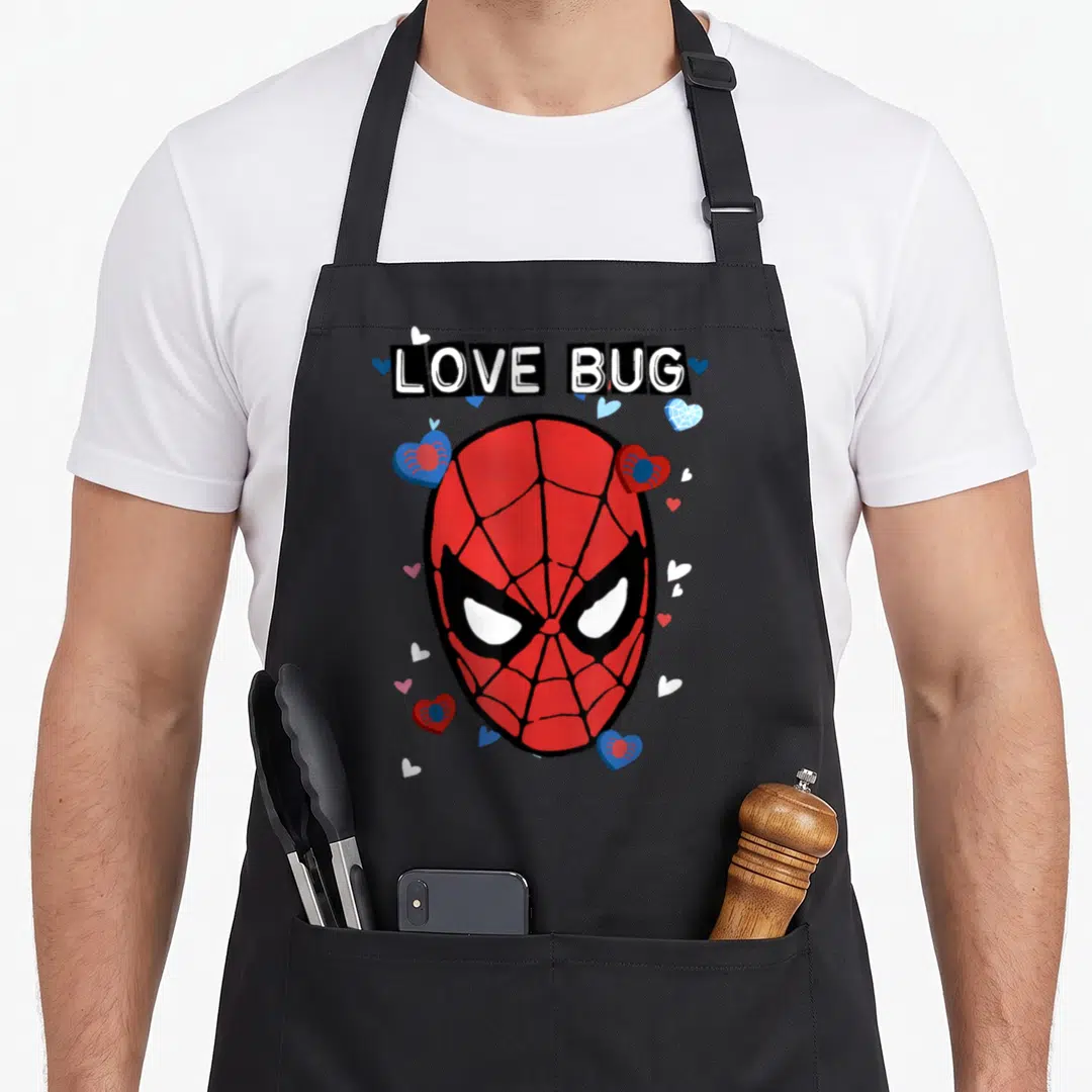 Bug valentine's day apron - LOVE BUG text above Spider-Man mask with hearts and small spiders in red blue white black — shown on a black cotton canvas apron against a white background