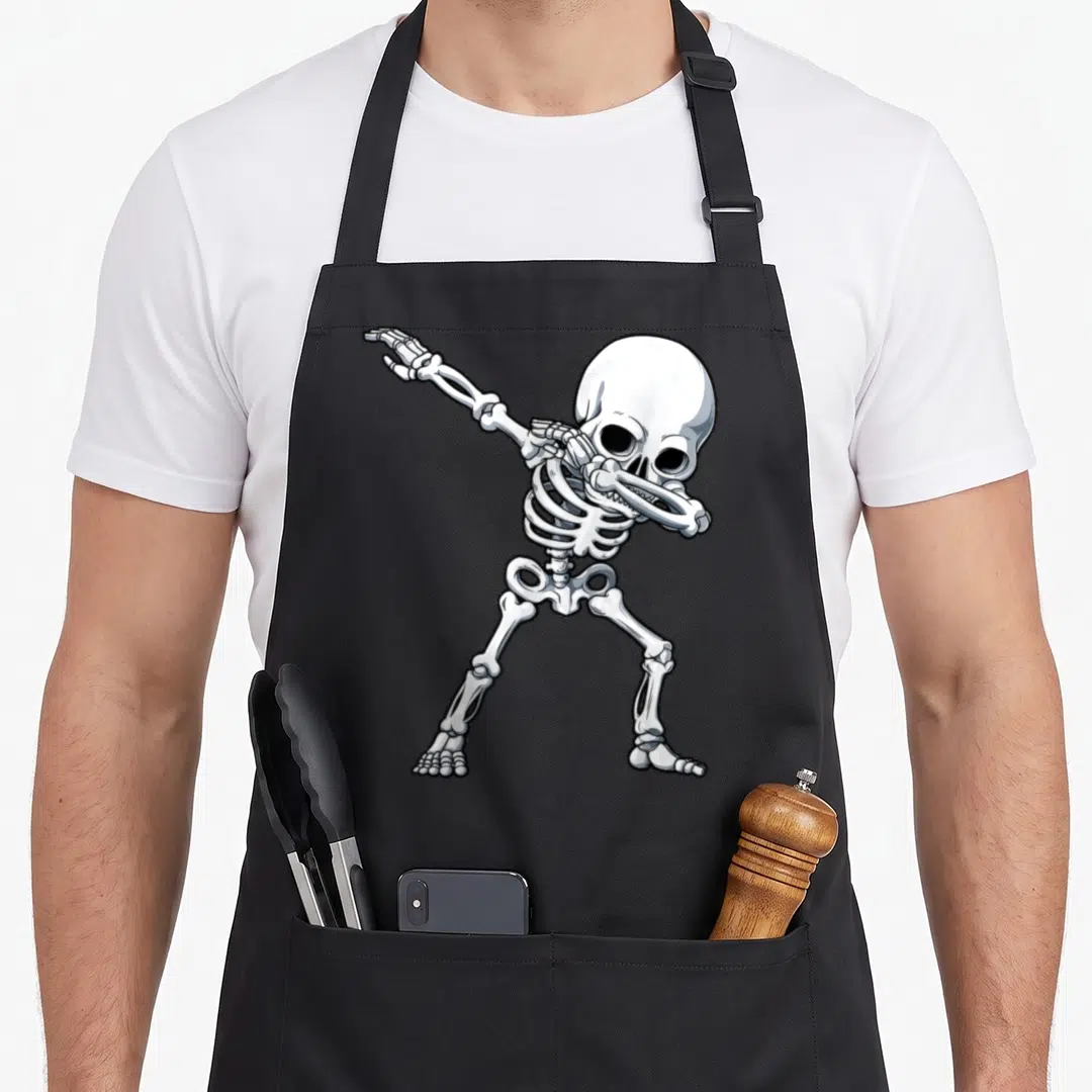 Halloween dabbing skeleton apron - White and grey cartoon skeleton figure in a dynamic dabbing dance pose with black — shown on a black cotton canvas apron against a white background