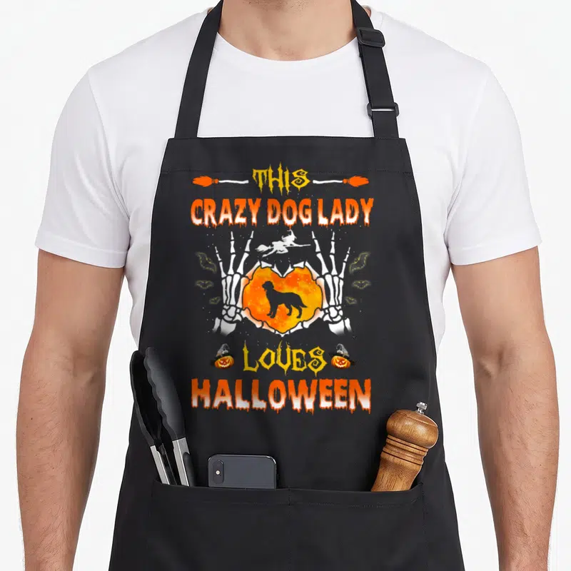 Irish setter dog apron - Skeleton hands holding orange heart with dog silhouette and Halloween text — shown on a black cotton canvas apron against a white background