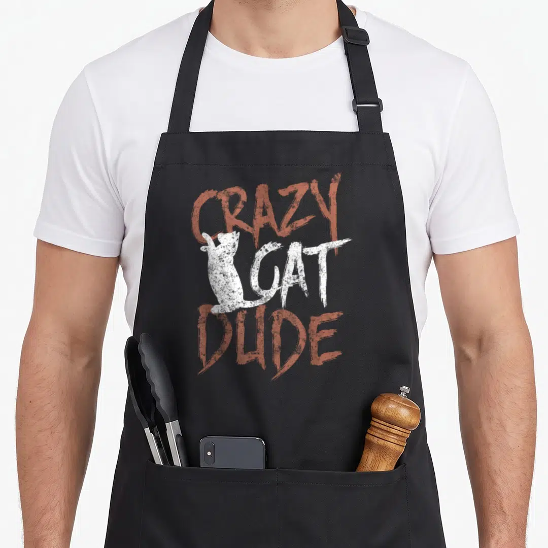 Dude black cat aprons - Distressed red and white text reading CRAZY CAT DUDE with white cat silhouette — shown on a black cotton canvas apron against a white background