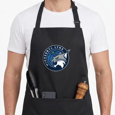 Wnba sports fan apron - Circular logo with lynx head over basketball and curved text in navy, blue, white, and green — shown on a black cotton canvas apron against a white background