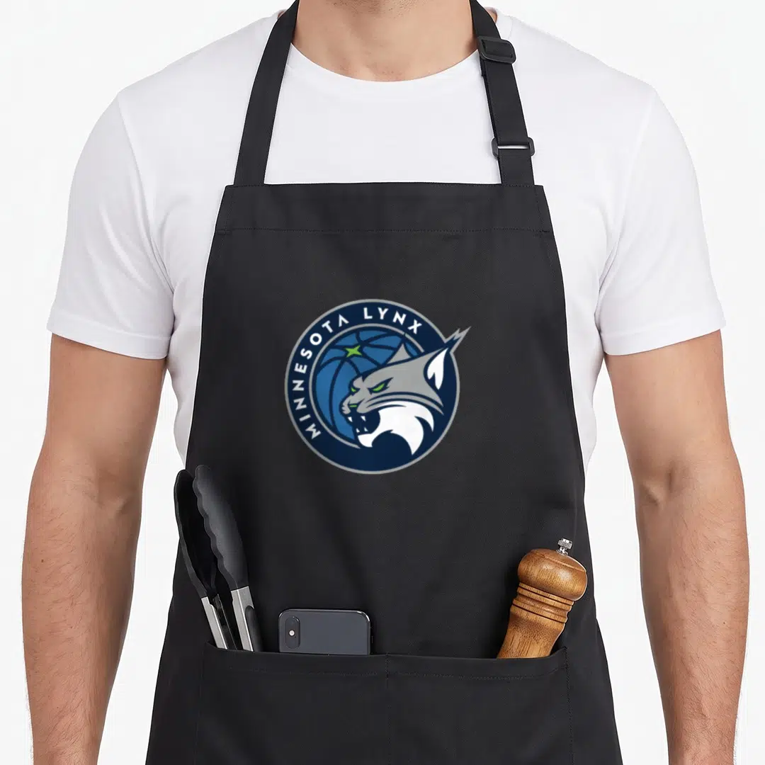 Wnba sports fan apron - Circular logo with lynx head over basketball and curved text in navy, blue, white, and green — shown on a black cotton canvas apron against a white background