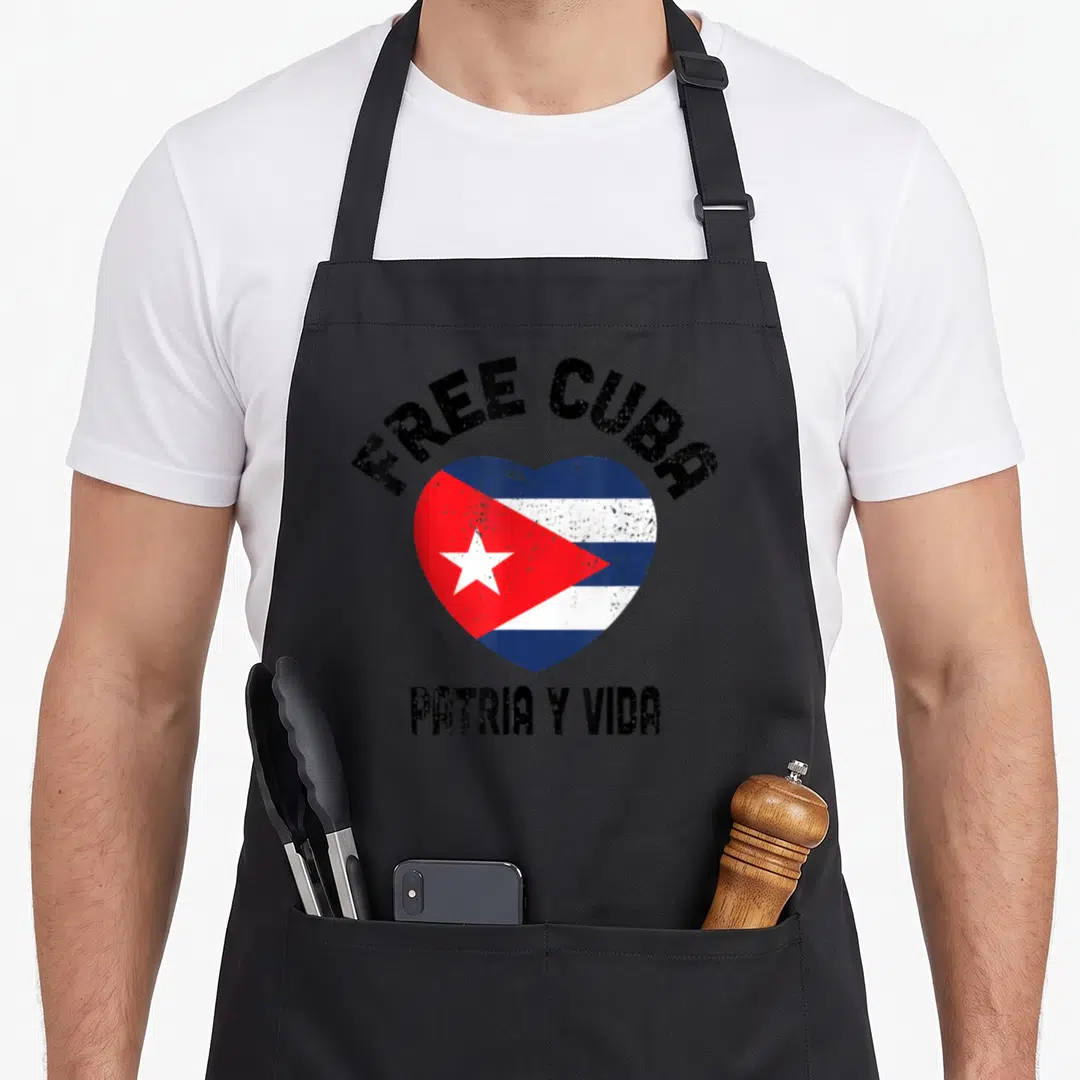 Patria vida cuba libre apron - Distressed heart with Cuban flag and text FREE CUBA PATRIA Y VIDA — shown on a black cotton canvas apron against a white background