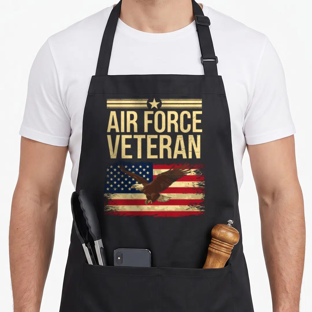 Memorial us aprons - Distressed eagle flying over US flag below stacked AIR FORCE VETERAN text — shown on a black cotton canvas apron against a white background