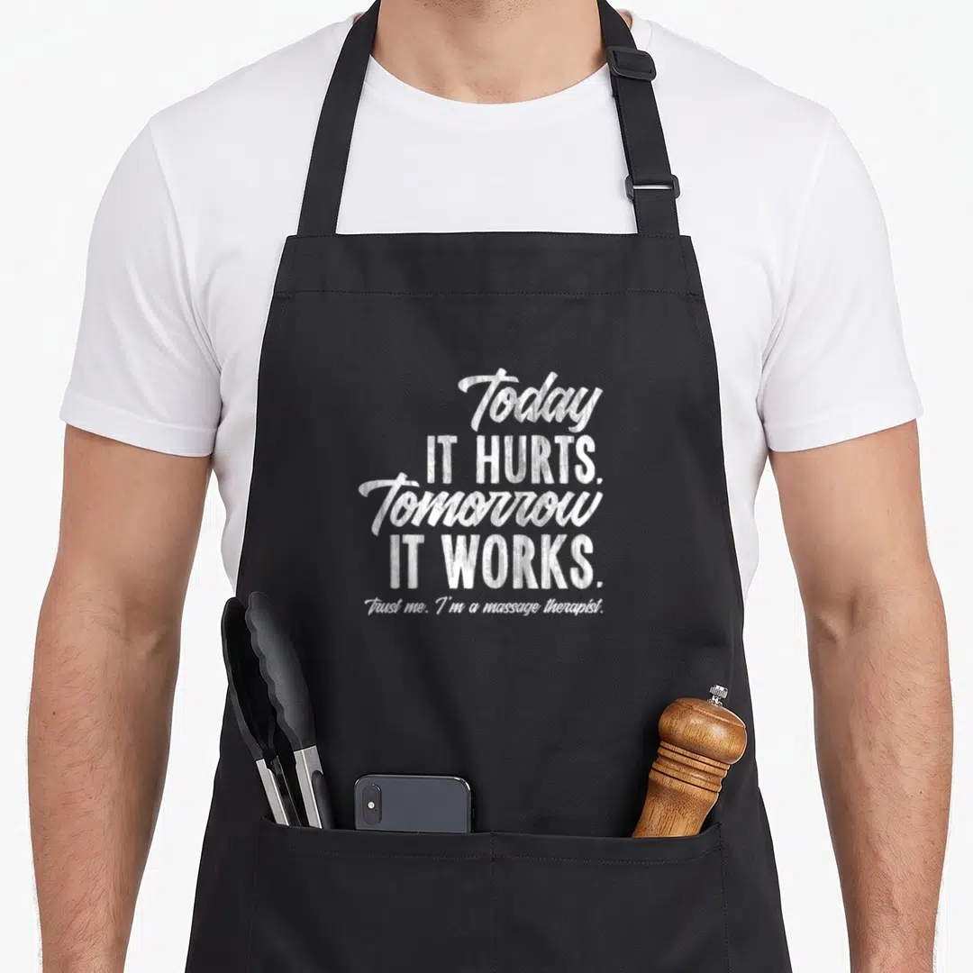 Funny massage therapist apron - White stacked text reading Today IT HURTS Tomorrow IT WORKS Trust me Im a massage — shown on a black cotton canvas apron against a white background