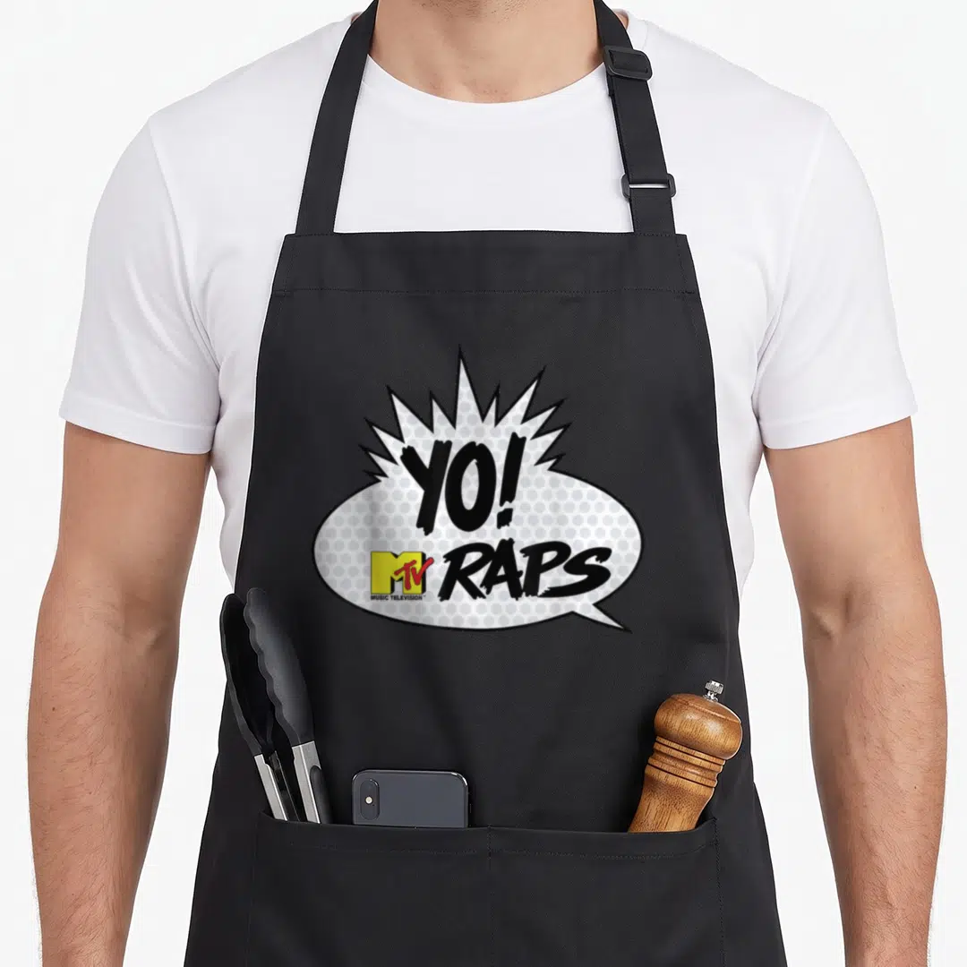 Mtv hip hop apron - YO! RAPS text in comic speech bubble with yellow MTV logo and halftone dots — shown on a black cotton canvas apron against a white background