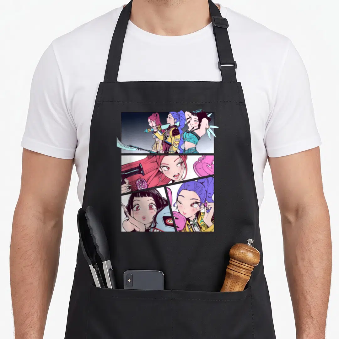 Manhwa trend apron - Three women in pink purple blue yellow cartoon comic grid panels — shown on a black cotton canvas apron against a white background