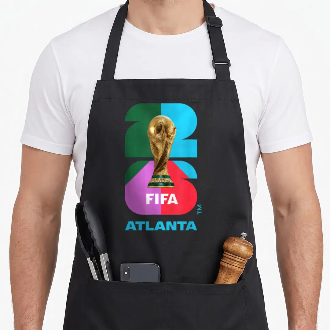Cup26 world cup apron - Gold trophy over green blue purple and red 26 with FIFA and Atlanta text — shown on a black cotton canvas apron against a white background