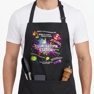 Vacation crew apron - Disco ball radiating multicolored light surrounded by lamps and religious text about Jesus — shown on a black cotton canvas apron against a white background