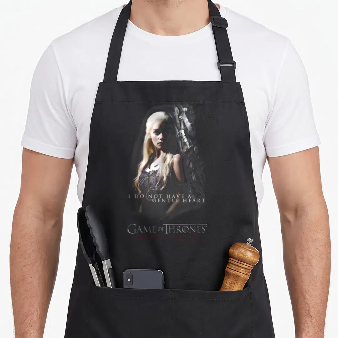 Daenery gentle apron - I Do Not Have A Gentle Heart text over woman portrait with Game of Thrones logo — shown on a black cotton canvas apron against a white background