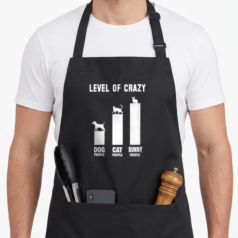 Owner level bunny apron - White bar chart showing bunny people highest on level of crazy scale — shown on a black cotton canvas apron against a white background